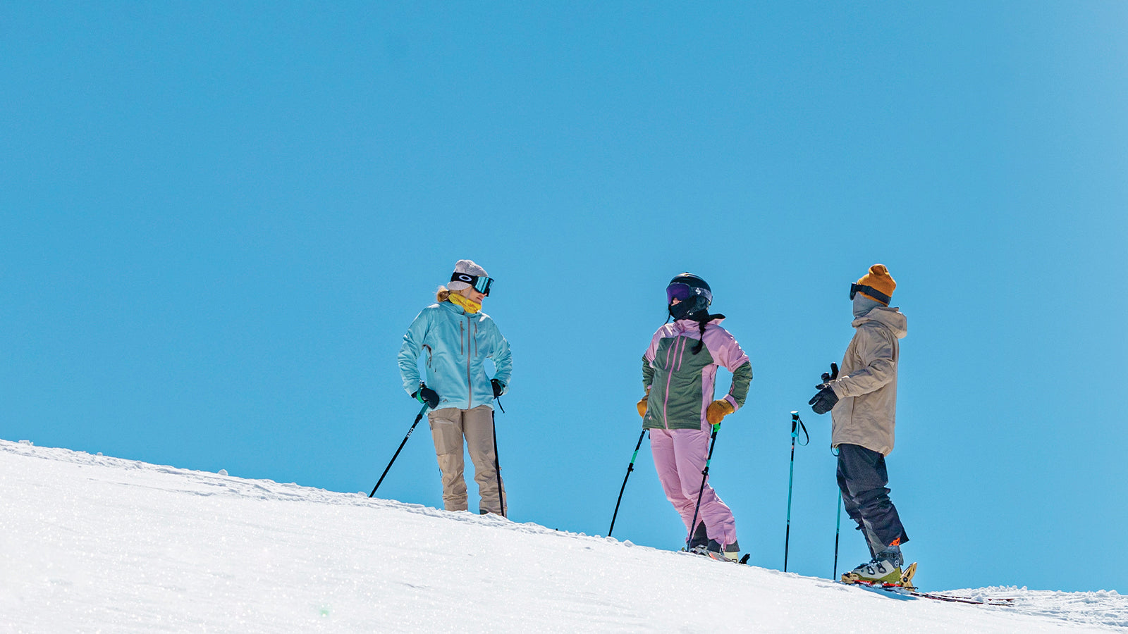 three skiers stopped talking on ski slope