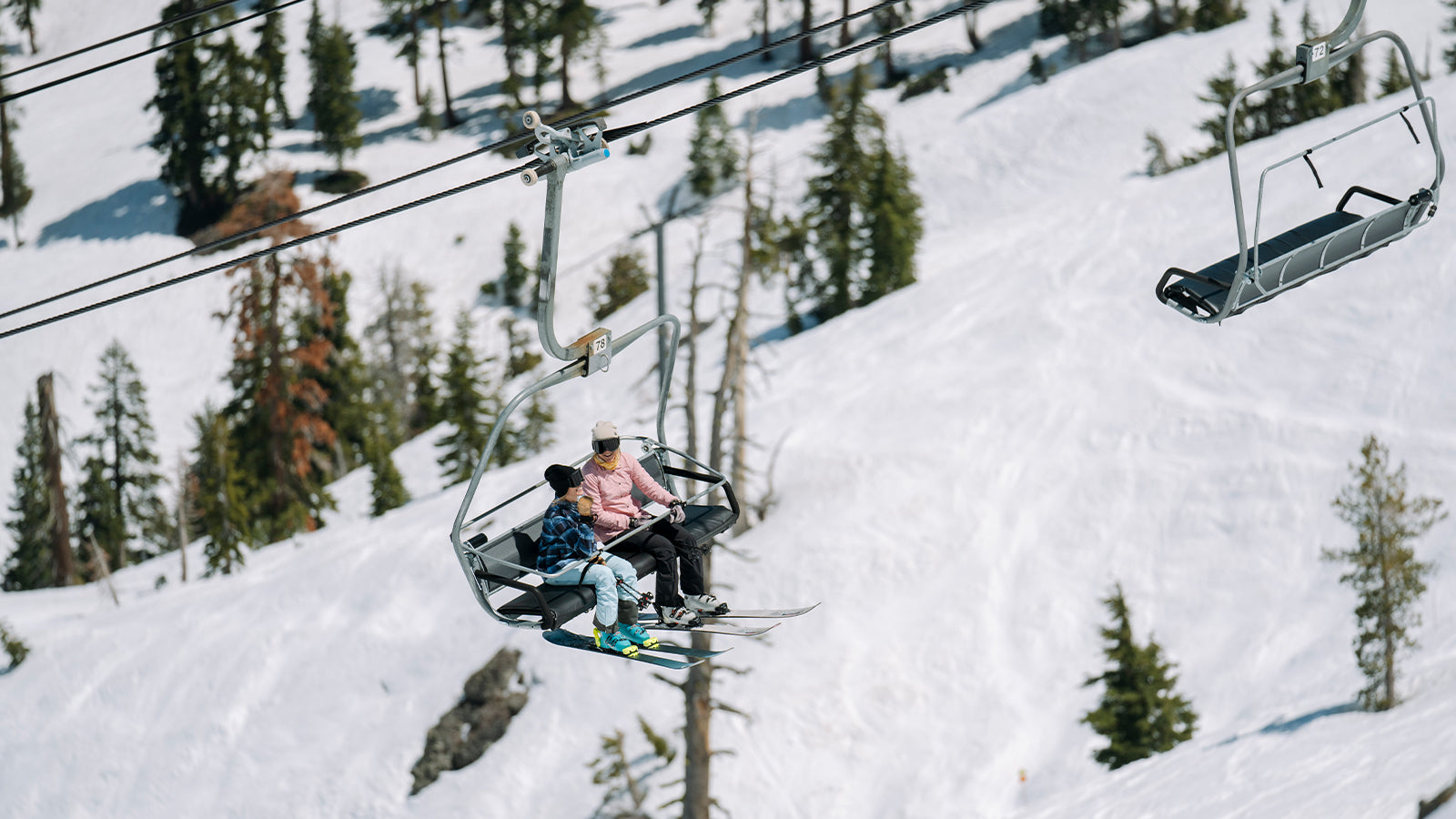 SKIER GALS RIDING LIFT