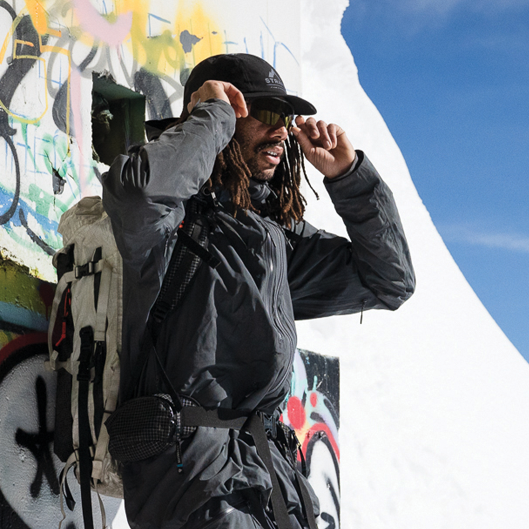 man leaned up against graffiti wall wearing strafe nomad kit