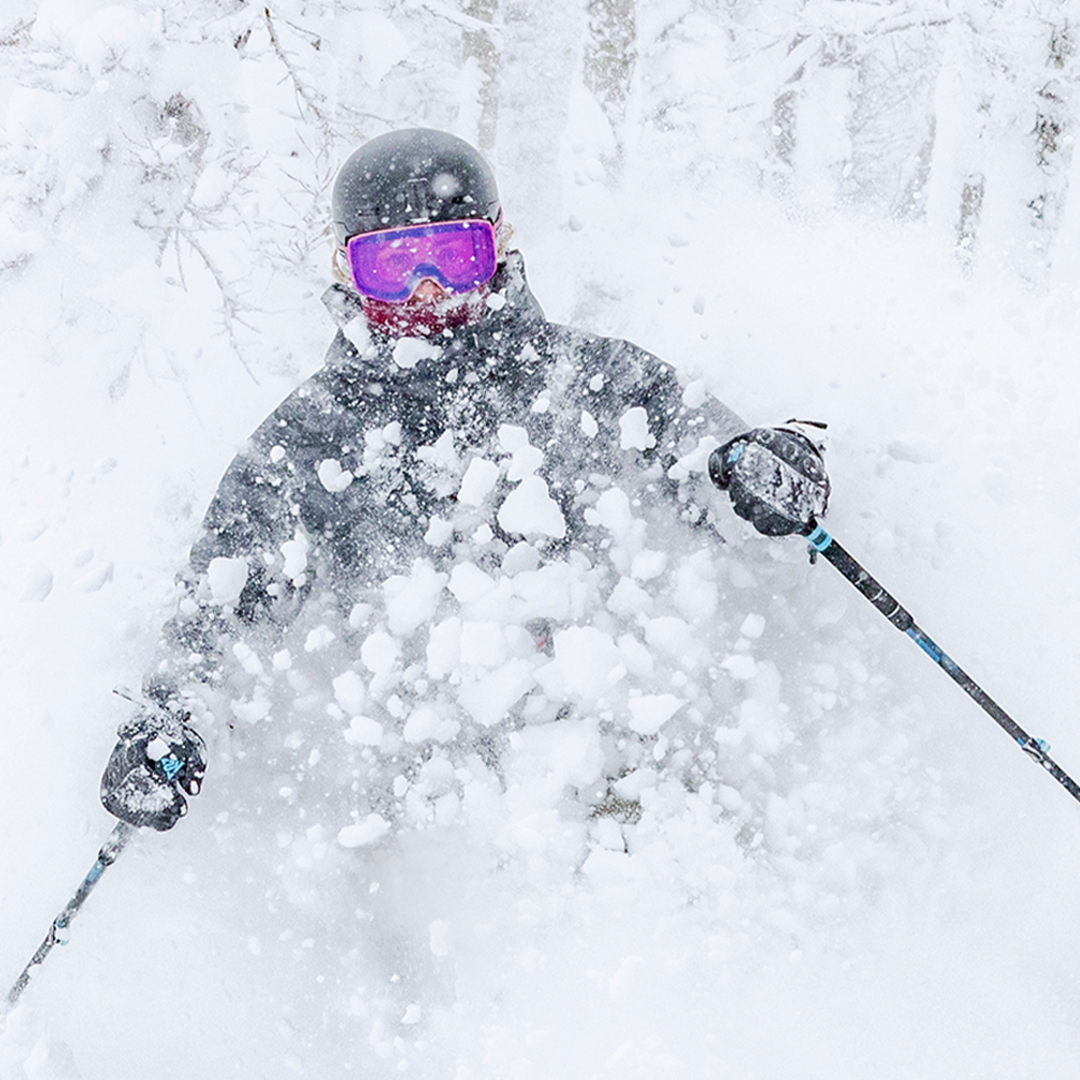 woman skiing powder wearing lucky insulated jacket